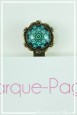 marque-pages-cabochon-roue-psychedelique-couleur-turquoise-et-bleu-avec-livre-zoom